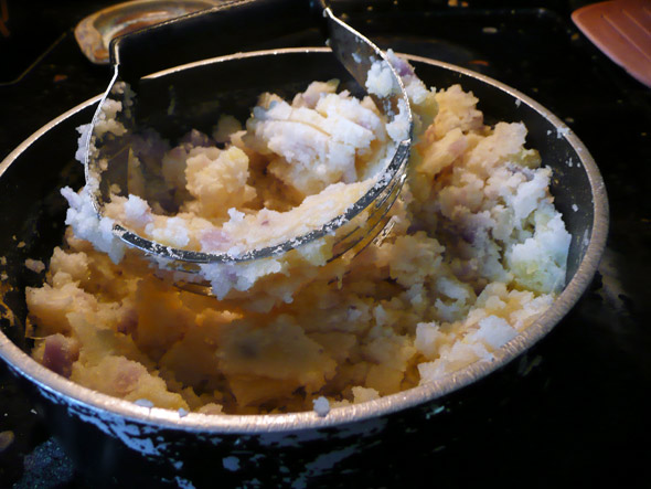 Mashing the potatoes with a pastry cutter! 