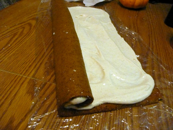Rolling up the pumpkin roll with the filling