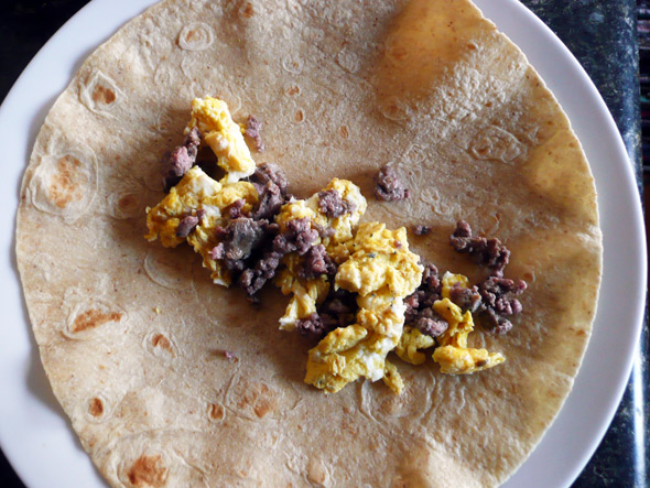 Assembling the Burritos: put the eggs and sausage or bacon on the tortilla