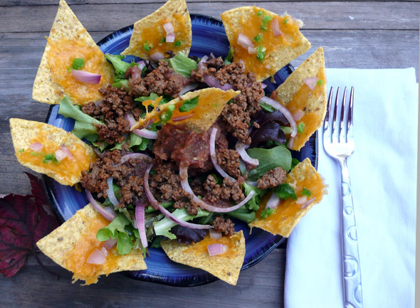 Nacho Salad with Refried Beans, Taco Meat, Nachos, Onions, & Salsa