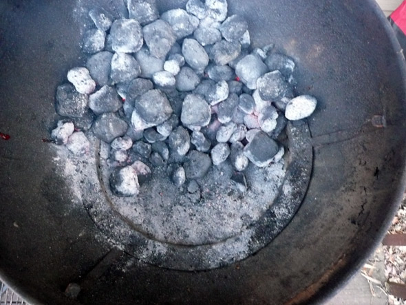 Piling the coals up on one side of the grill to make a hotspot