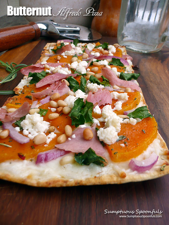 Butternut Alfredo Pizza ~ you will totally fall in love with this sweet & savory pizza! Thin sliced butternut squash roasted with garlic & herbs, with prosciutto, red onion, pine nuts, crumbled goat cheese and a bit of kale